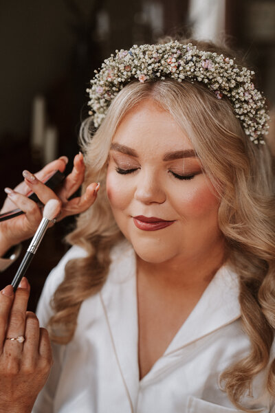Bride sits with heart shaped gallses on with wine in bathtub