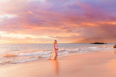 Woman in rose Kasia Kulenty maternity gown photographed on the beach in Maui by Love + Water