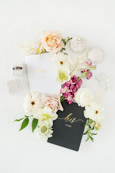 Bride and groom's vow books lie with flowers.