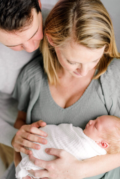 newborn baby with family photograph