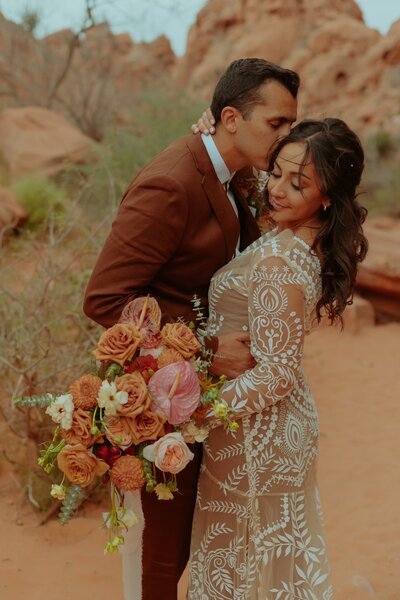 man kissing woman's cheek in canyon elopement