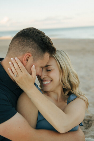 A candid engagement photo of a couple on the shoreline at Kohler-Andrae State Park in Sheboygan, Wisconsin. Captured by Alexia Rodriquez, a Midwest and destination photographer specializing in natural, editorial-style engagement imagery.