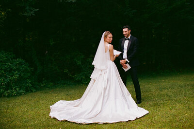 Bride and groom standing in front of beach house