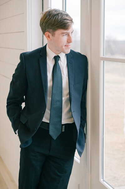The Nest at Ruth Farms Wedding Venue | DFW Wedding Photographer Rae De Lain Light and Airy | Groom looking out the window