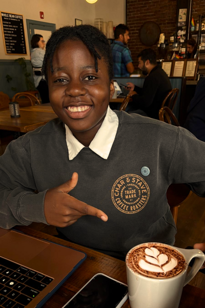 Ryan Shelton college student Towson University and PR Intern at Bird Hill. Smiling outdoors in natural light while wearing a coral shirt.