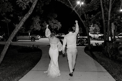 Black and white image of bride and groom leaving joyful Central Texas wedding