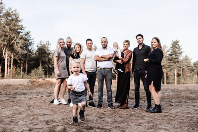 Familieshoot opa oma kinderen en kleinkinderen in sevenum op de zandvlakte meisje rent naar camera toe