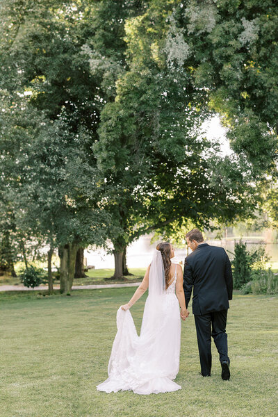 Bride and groom stroll through the lawns on their wedding day in Fresno at Wolf Lakes Park