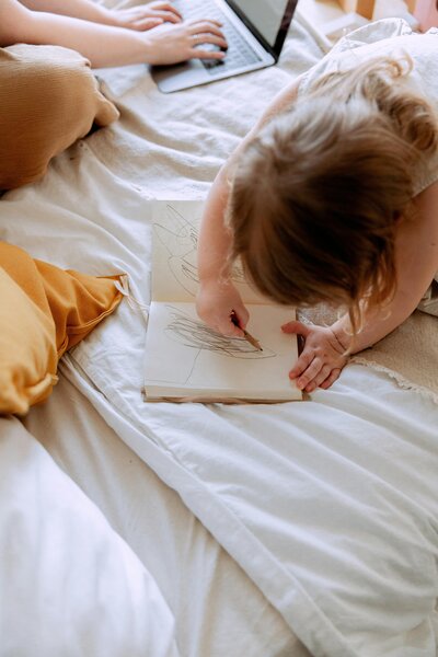 A touching home office scene featuring a mom working from home with a child's drawing, illustrating the balance of work and family life. Creative Dynamics supports moms with flexible virtual assistant services, helping them manage business tasks while cherishing family moments. Read our blog for tips and insights on thriving in a home-based work environment. Photo courtesy of Unsplash.