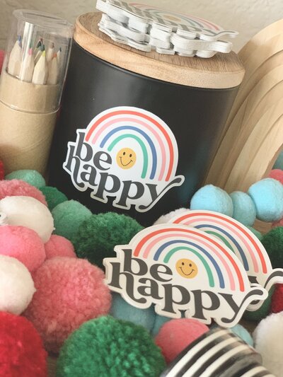 Be happy in retro font sticker with colorful rainbow bundle  on colored pompoms