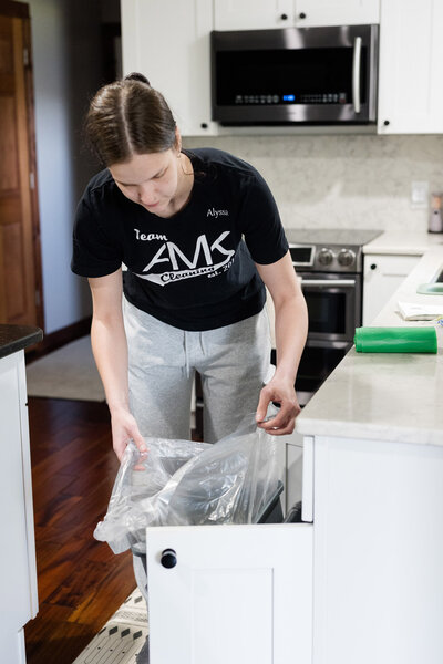 Professional cleaner taking out trash