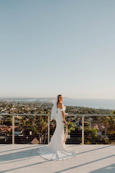 a bride standing on a balcony overlooking the city