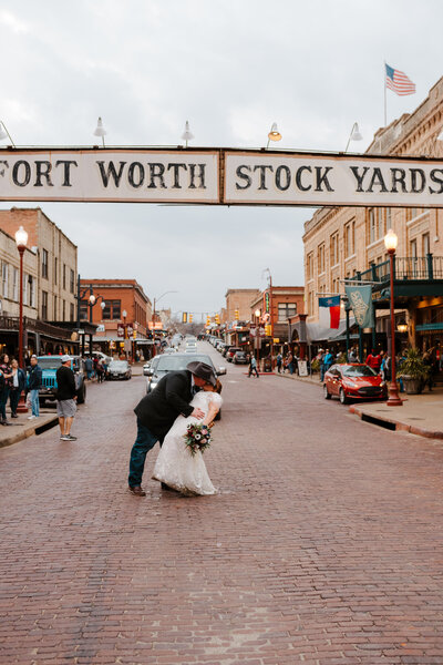 bride and groom kissing in street