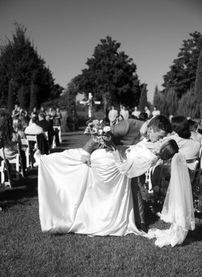 groom dipping his bride at the end of the isle 