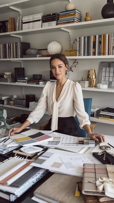 Female business owner at modern desk reviewing branding and website design materials