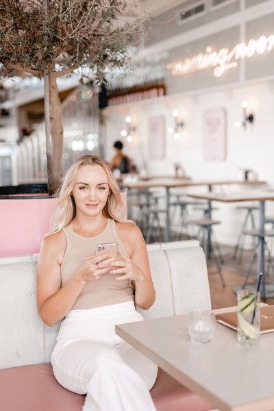Hollie looking at the camera while sitting on stool smiling