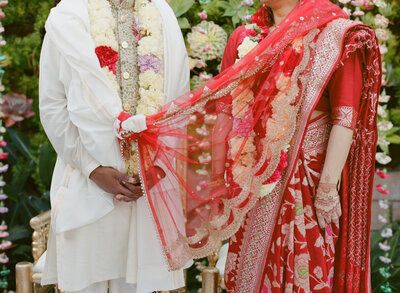 Hindu Bride and Groom cradle hands at wedding ceremon