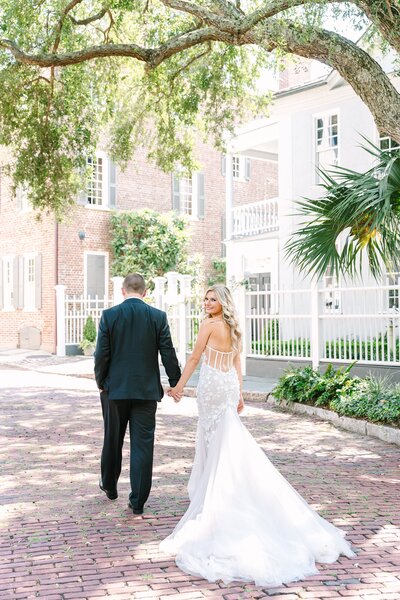 bride and groom romantic portrait in front of an iron gate at Ford Field and River Club in Savannah GA by destination wedding photographer Dana Cubbage Weddings.