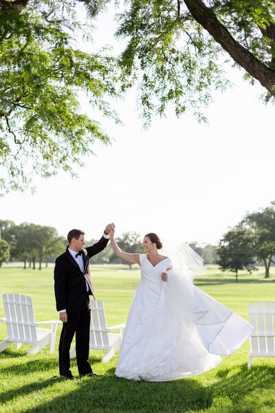 groom twirls bride for portraits at Lake Forest, IL country club
