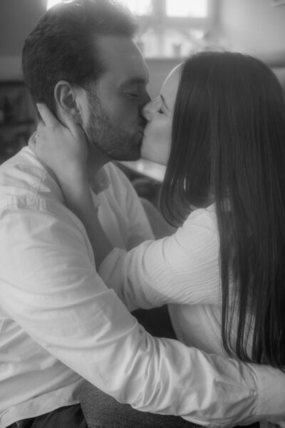 Ein sich küssendes Paar in einer engen Umarmung mit geschlossenen Augen.