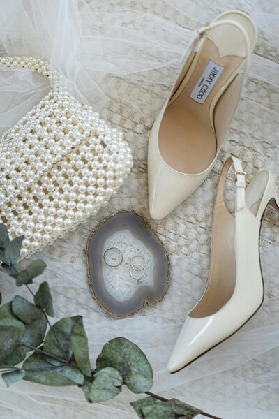 Close-up of the accessoiries of the bride: a beautiful pearl purse and classy white heels.