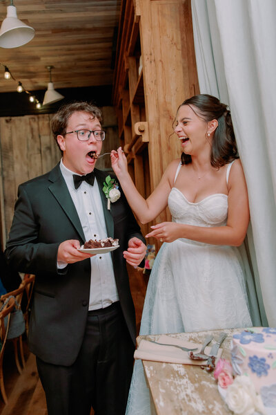 A newlywed feeding their partner cake at their wedding reception 