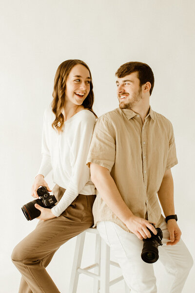 man and woman holding cameras