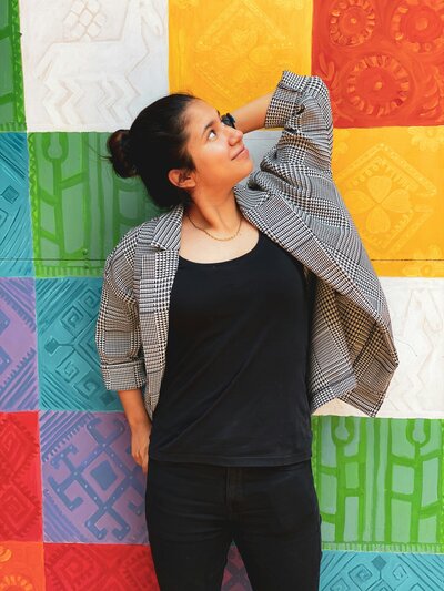 Young lesbian woman standing against a multi-colored background