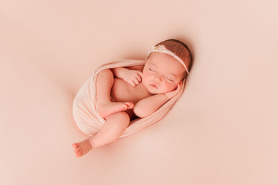 newborn portrait with pink outfit and background.