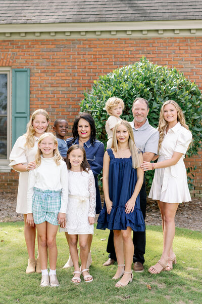 Family smiling in front of a house