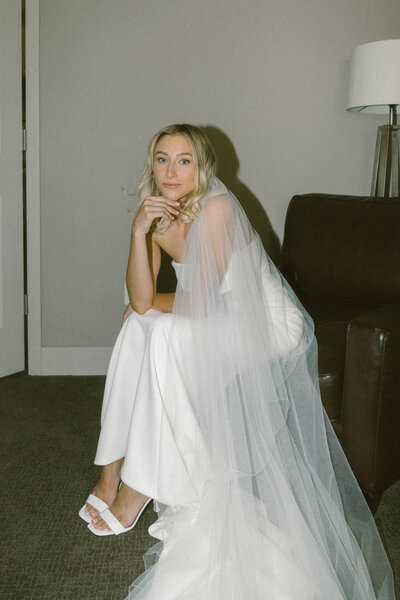 bride in her dress sitting on a chair