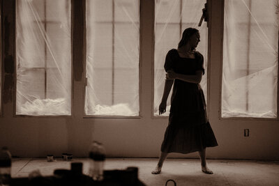 Ballerina dances in their home during a full remodel. She's surrounded by tools, trash, and construction sites.