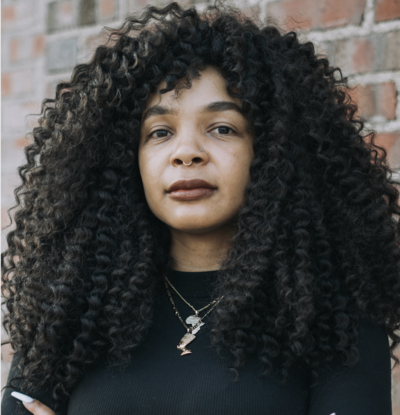 Black woman wearing a black shirt with long curly black hair