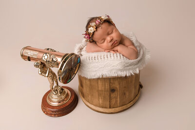 pregnant woman standing in a white gown, in a forest setting holding her pregnant belly looking down in awe.