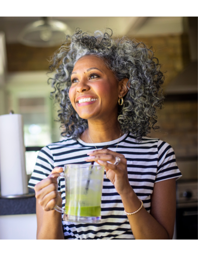 Beautiful woman smiling drinking green smoothie