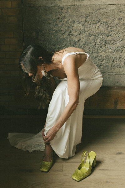 bride puts on wedding shoes during getting ready moments