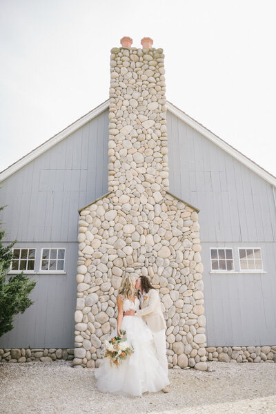 a married couple kisses on their wedding day outside of Bonnet Island Estate 