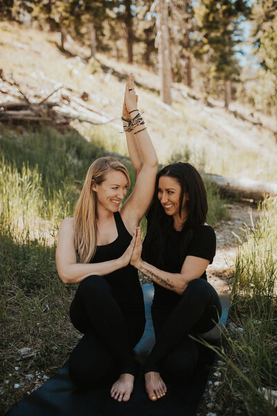 two women doing yoga poses in the desert