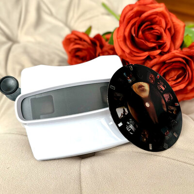 White viewfinder with a reel laying next to it