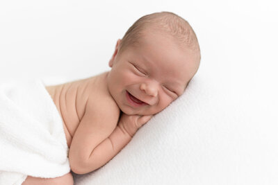 Smiling newborn on beanbag in studio