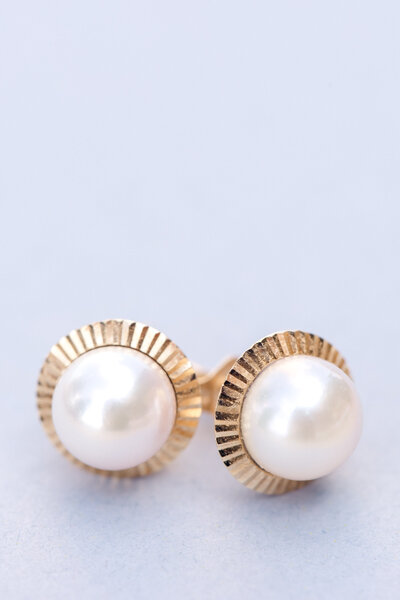 Close up of pearl earrings with gold backs