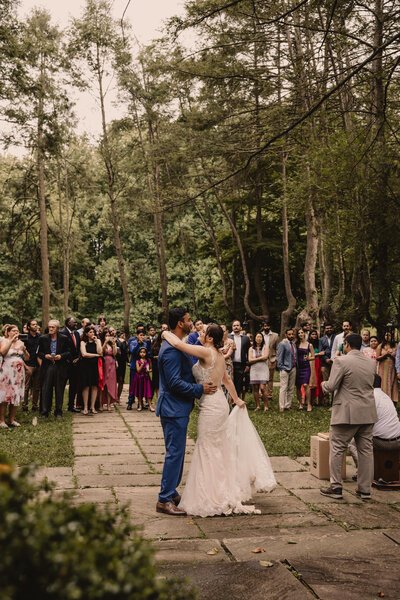 A newlywed couple dancing in front of their wedding guests 