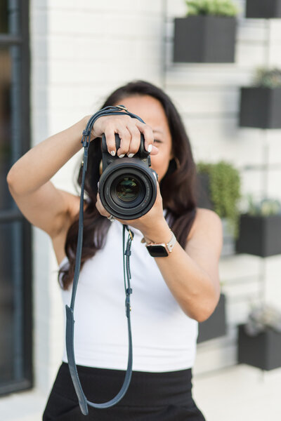 Brand photographer in Dallas looking through camera