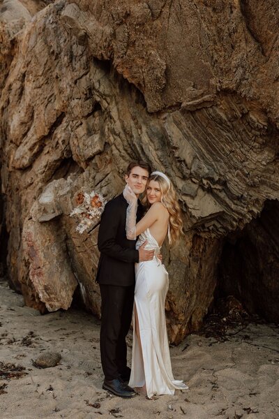 bride and groom embracing with cheeks together looking at the camera