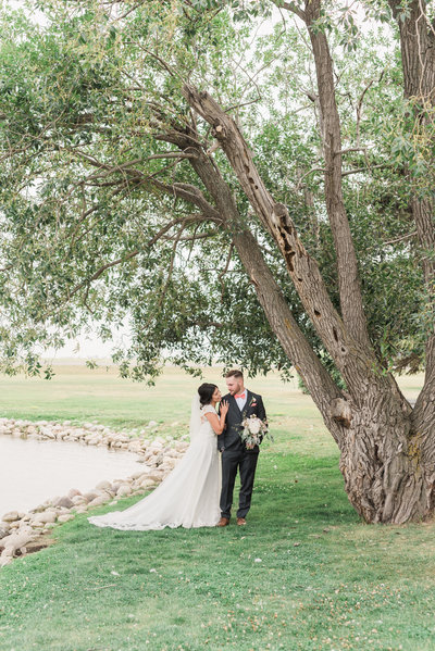 wedding photo of couple standing under a tree