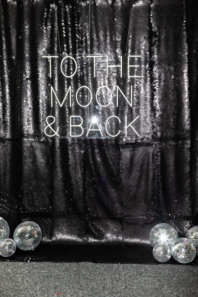 premium black sequins backdrop with To the moon and black neon sign for weddings and corporate events