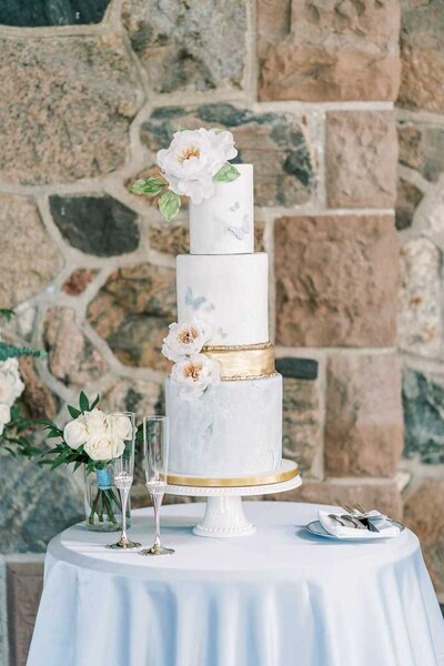 blue fondant wedding cake with wafer paper flowers and gold