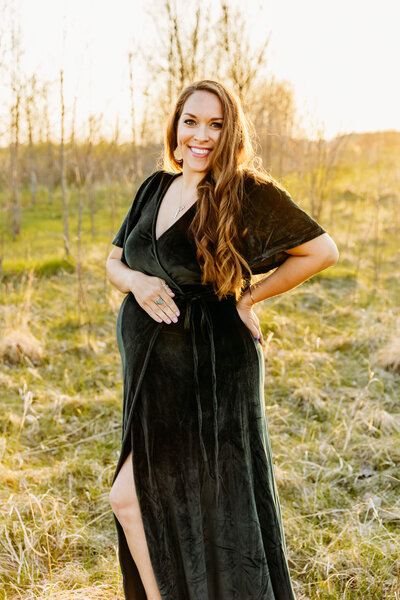 pretty mama to be smiling as she poses during her maternity photo session