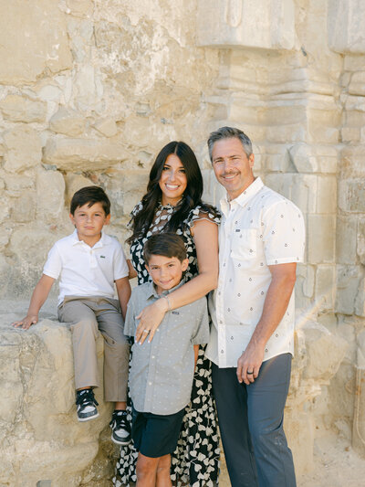 Mother and father hold their two young boys for family portrait at park