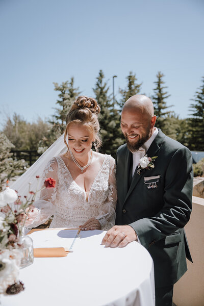 Couple signing their marriage license during their outdoor ceremony at Flores and Pine in Calgary